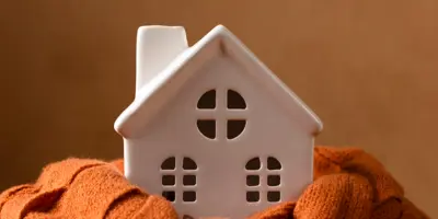 image of a white ceramic house encircled by a orange scarf