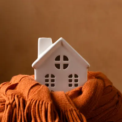 image of a white ceramic house encircled by a orange scarf